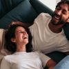 a couple laying on a sofa laughing