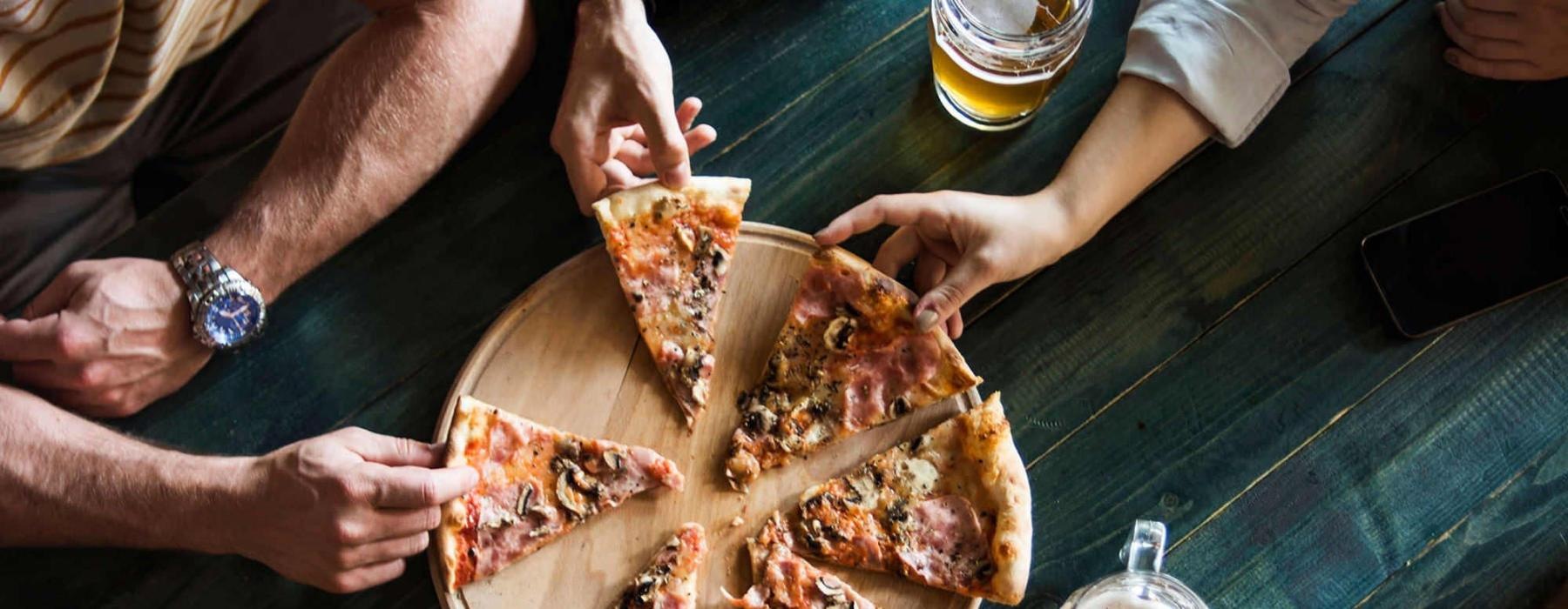 a group of people eating pizza